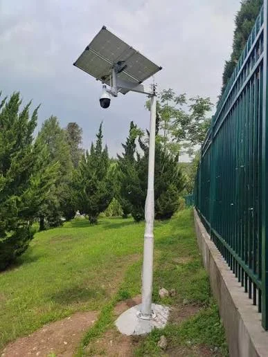 Off-grid solar-powered security camera mounted on pole beside boundary fence